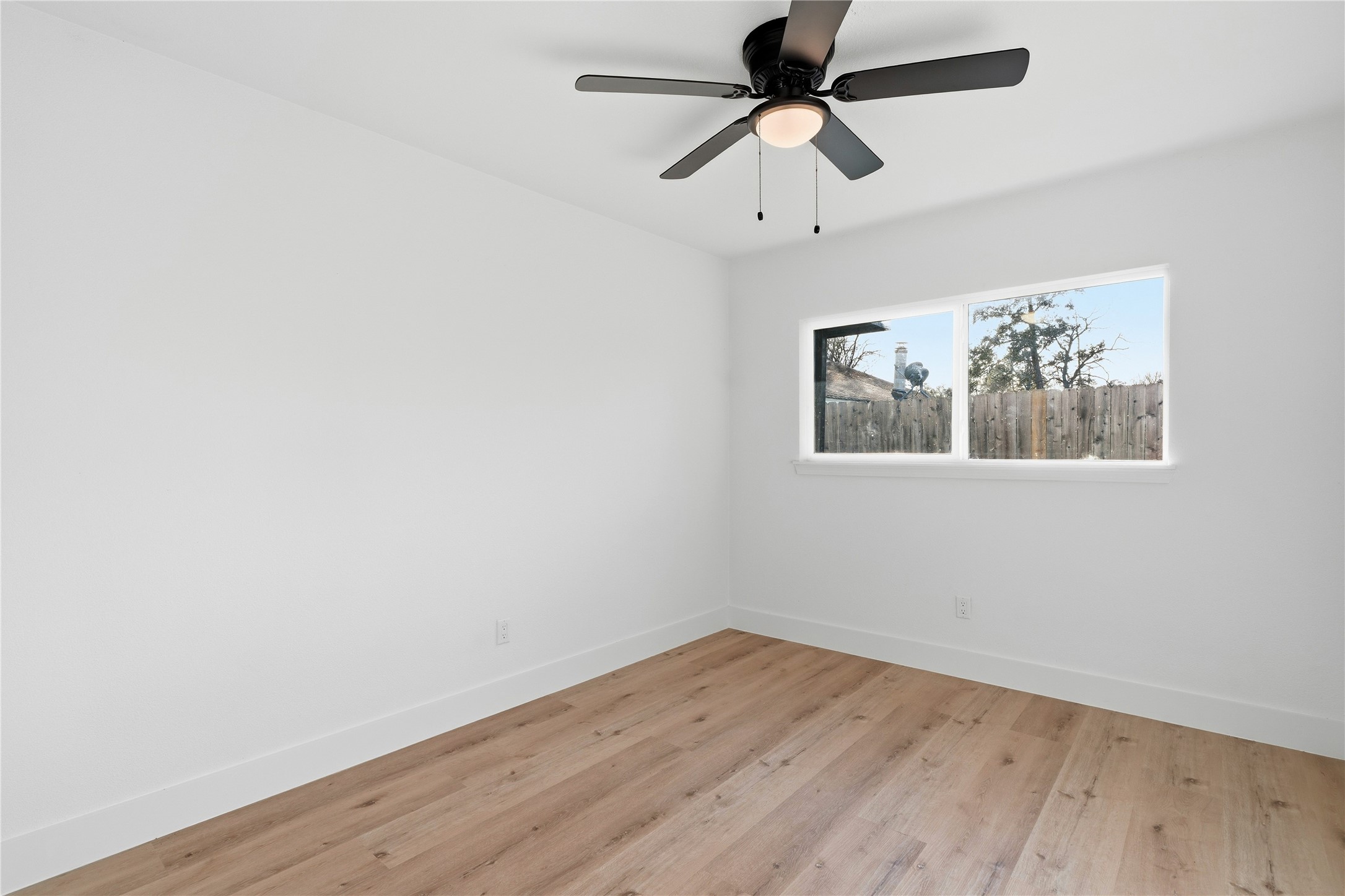 9809 Wren Court Conroe, TX 77385 - Photo 17 of 22 an empty room with wooden floor and ceiling fan