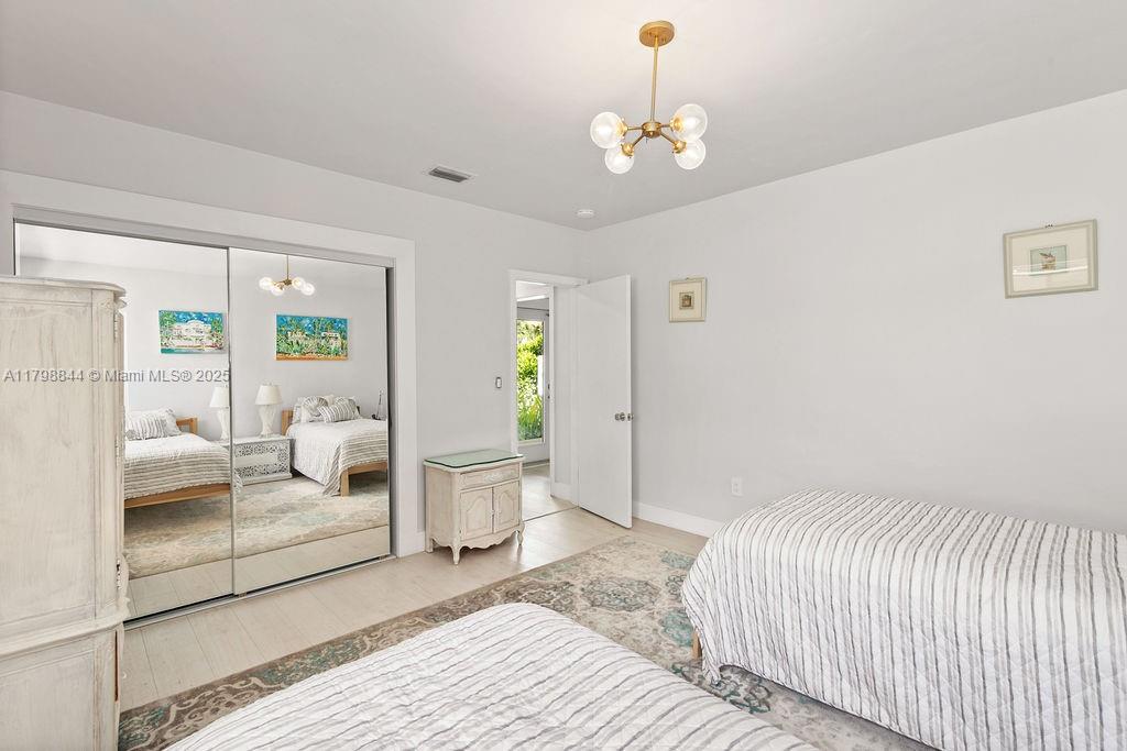 9025 Hawthorne Avenue Surfside, FL 33154 - Photo 11 of 58 a spacious bedroom with a bed and chandelier