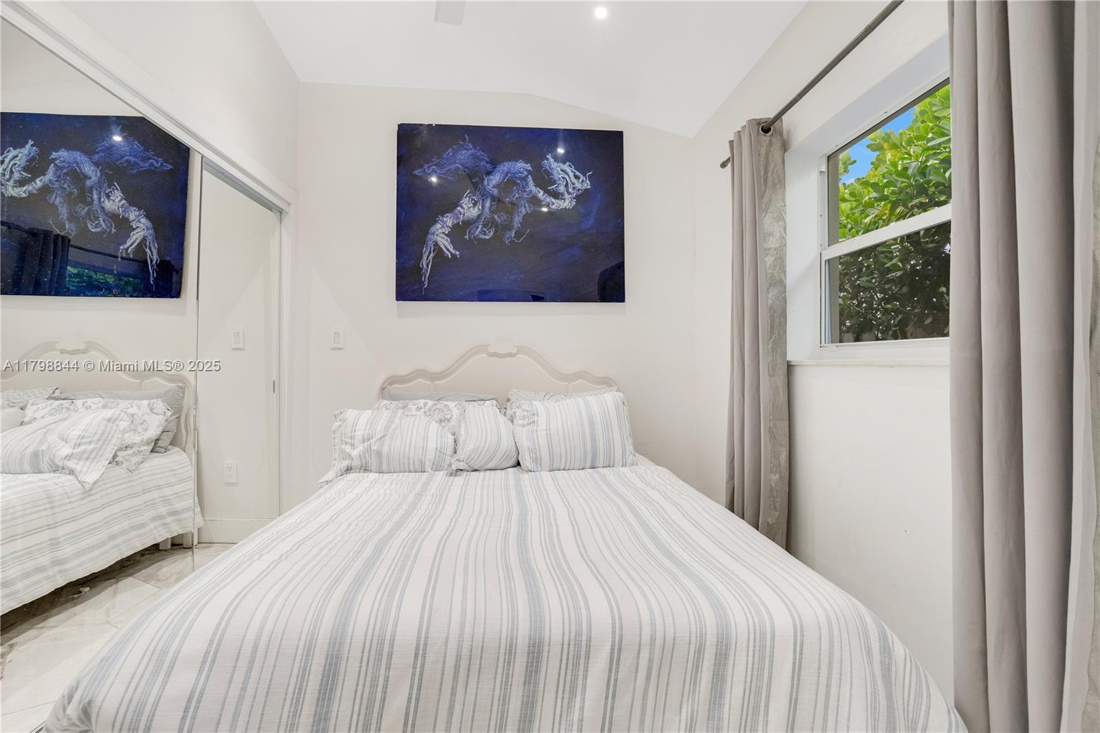9025 Hawthorne Avenue Surfside, FL 33154 - Photo 13 of 58 a bedroom with a large bed and a painting on the wall