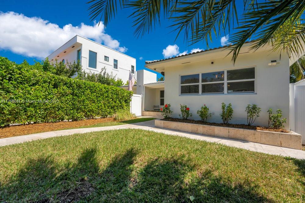 9025 Hawthorne Avenue Surfside, FL 33154 - Photo 2 of 58 a front view of a house with a yard and garage