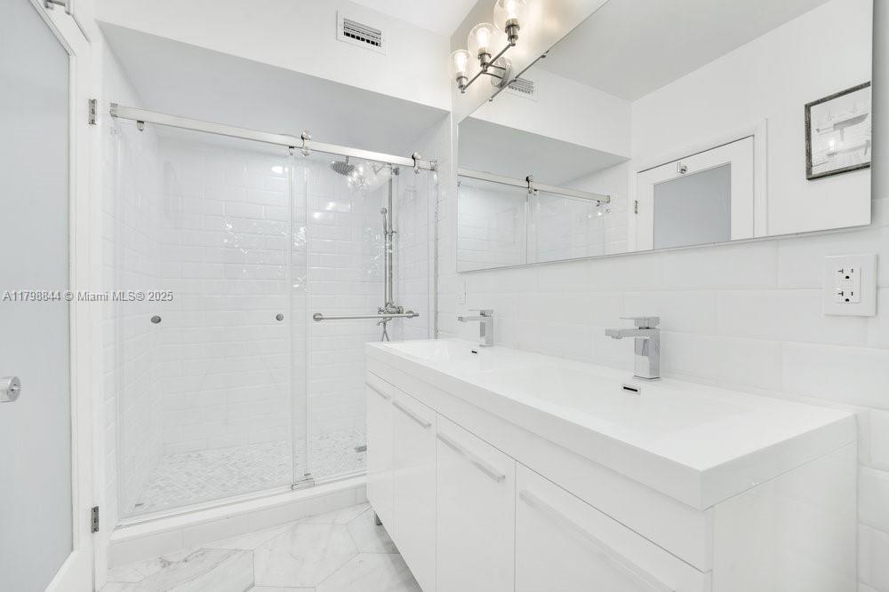 9025 Hawthorne Avenue Surfside, FL 33154 - Photo 28 of 58 a bathroom with a sink double vanity and shower