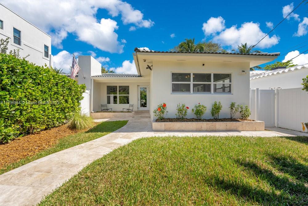 9025 Hawthorne Avenue Surfside, FL 33154 - Photo 41 of 58 a front view of a house with a yard and a garage