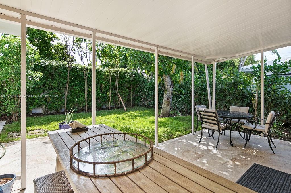 9025 Hawthorne Avenue Surfside, FL 33154 - Photo 44 of 58 a view of a patio with a table chairs and a backyard