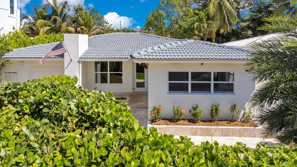 9025 Hawthorne Avenue Surfside, FL 33154 - Photo 5 of 58 a front view of a house with a yard and potted plants