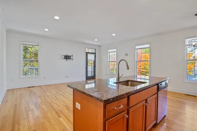 a kitchen with granite countertop a sink and a wooden floor