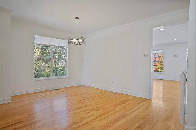 a view of empty room with window and wooden floor