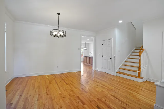 a view of empty room with wooden floor and window