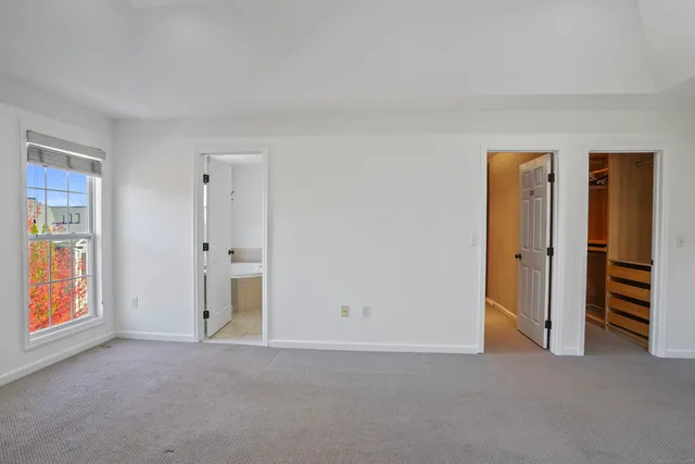 an empty room with closet and mirror
