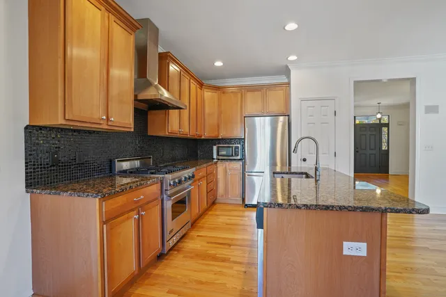 a kitchen with stainless steel appliances granite countertop a stove a sink and a refrigerator