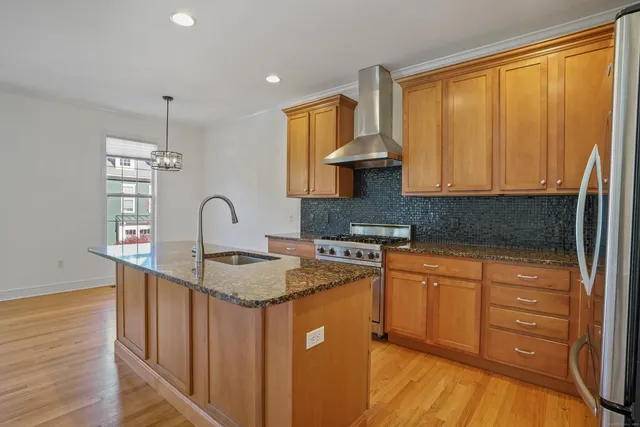 a kitchen with stainless steel appliances granite countertop a sink stove and cabinets