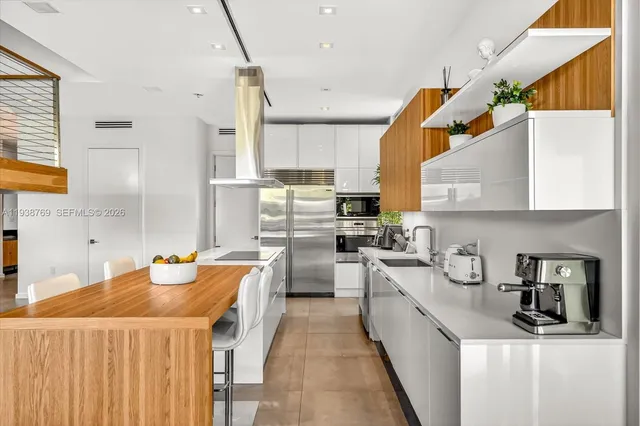 a kitchen with stainless steel appliances a sink a stove and a refrigerator