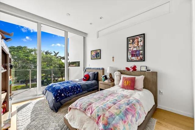 a bedroom with two beds and a large window