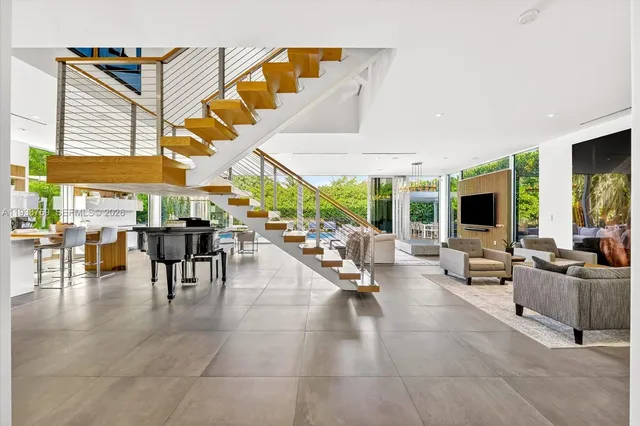 a living room filled with lots of furniture and a large window