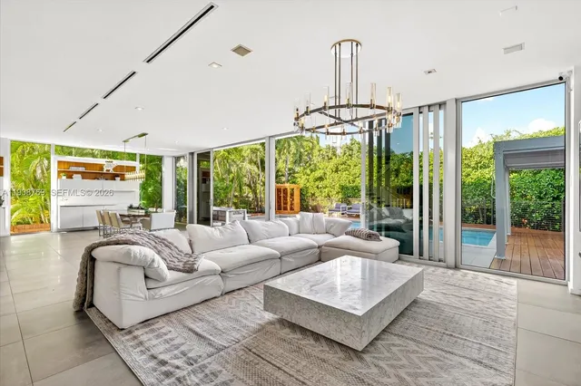 a living room with furniture a ceiling fan and a large window