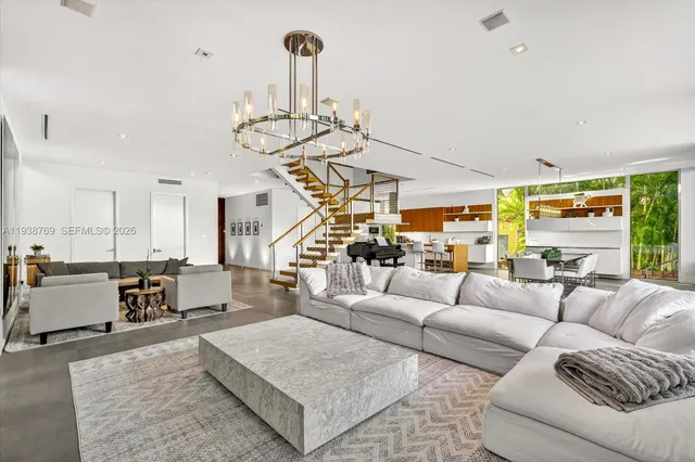 a living room with furniture chandelier and kitchen view