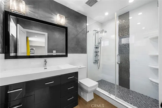 a bathroom with a toilet sink a shower and a mirror