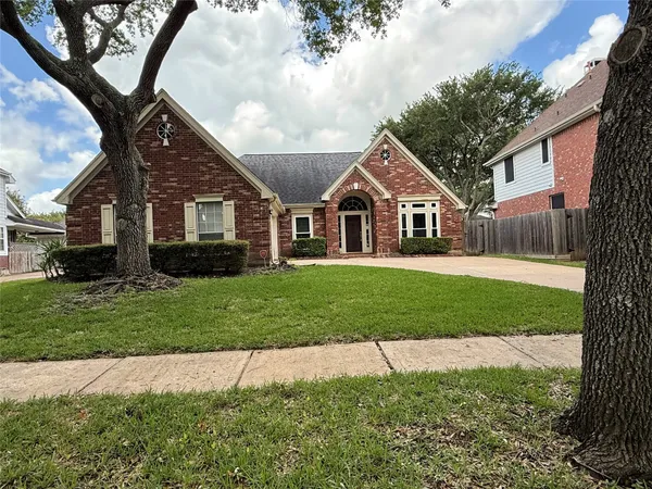 a front view of a house with a yard and trees