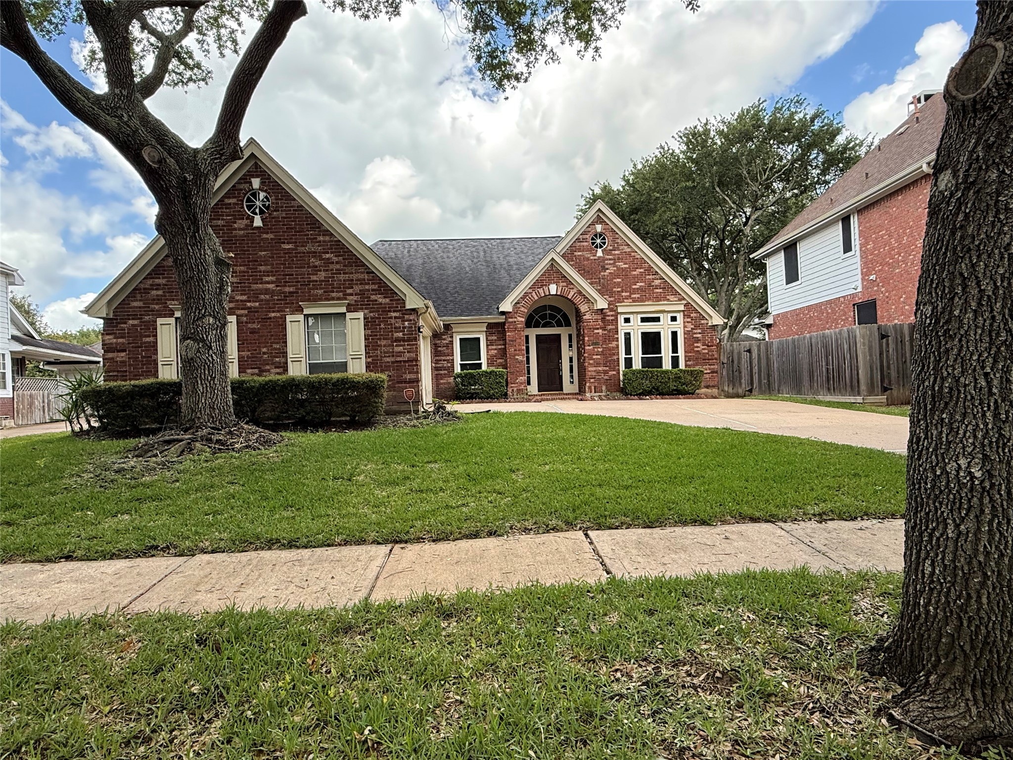 a front view of a house with a yard and trees
