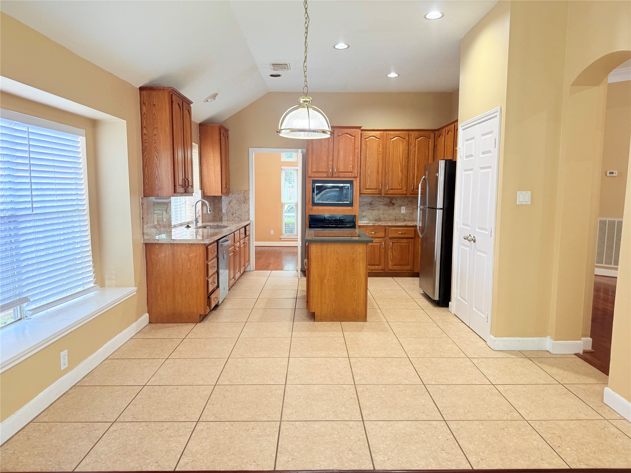 5010 Rebel Ridge Drive Sugar Land, TX 77478 - Photo 17 of 23 a kitchen with stainless steel appliances kitchen island granite countertop a refrigerator and a stove top oven