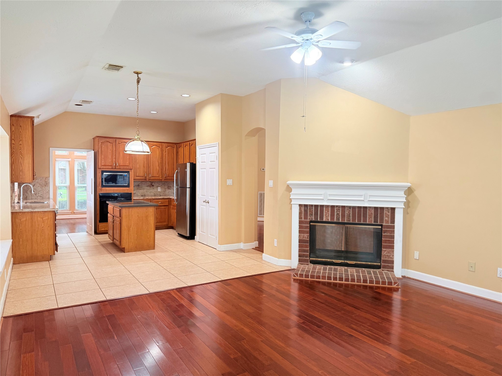5010 Rebel Ridge Drive Sugar Land, TX 77478 - Photo 5 of 23 a open kitchen with granite countertop a stove top oven a refrigerator and a fireplace