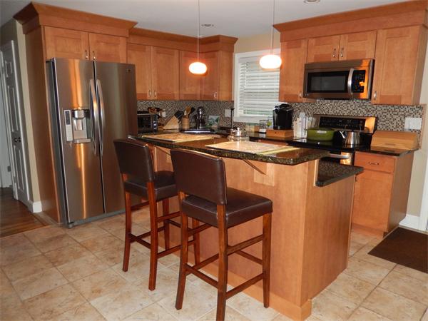 75 Chesbrough Road Boston, MA 02132 - Photo 1 of 16 a kitchen with stainless steel appliances granite countertop a stove a refrigerator a sink a dining table and chairs