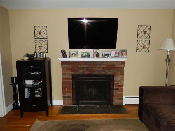 75 Chesbrough Road Boston, MA 02132 - Photo 4 of 16 a living room with a fireplace and a flat screen tv