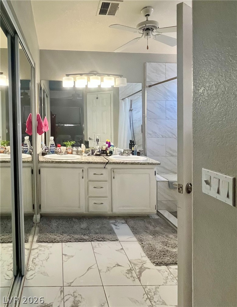15 Rue Des Champs Henderson, NV 89074 - Photo 9 of 23 A classic double vanity pairs with marble-look tile flooring in this primary bathroom.