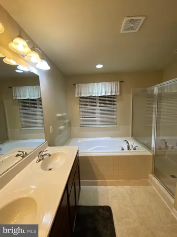 a bathroom with a tub sink and mirror
