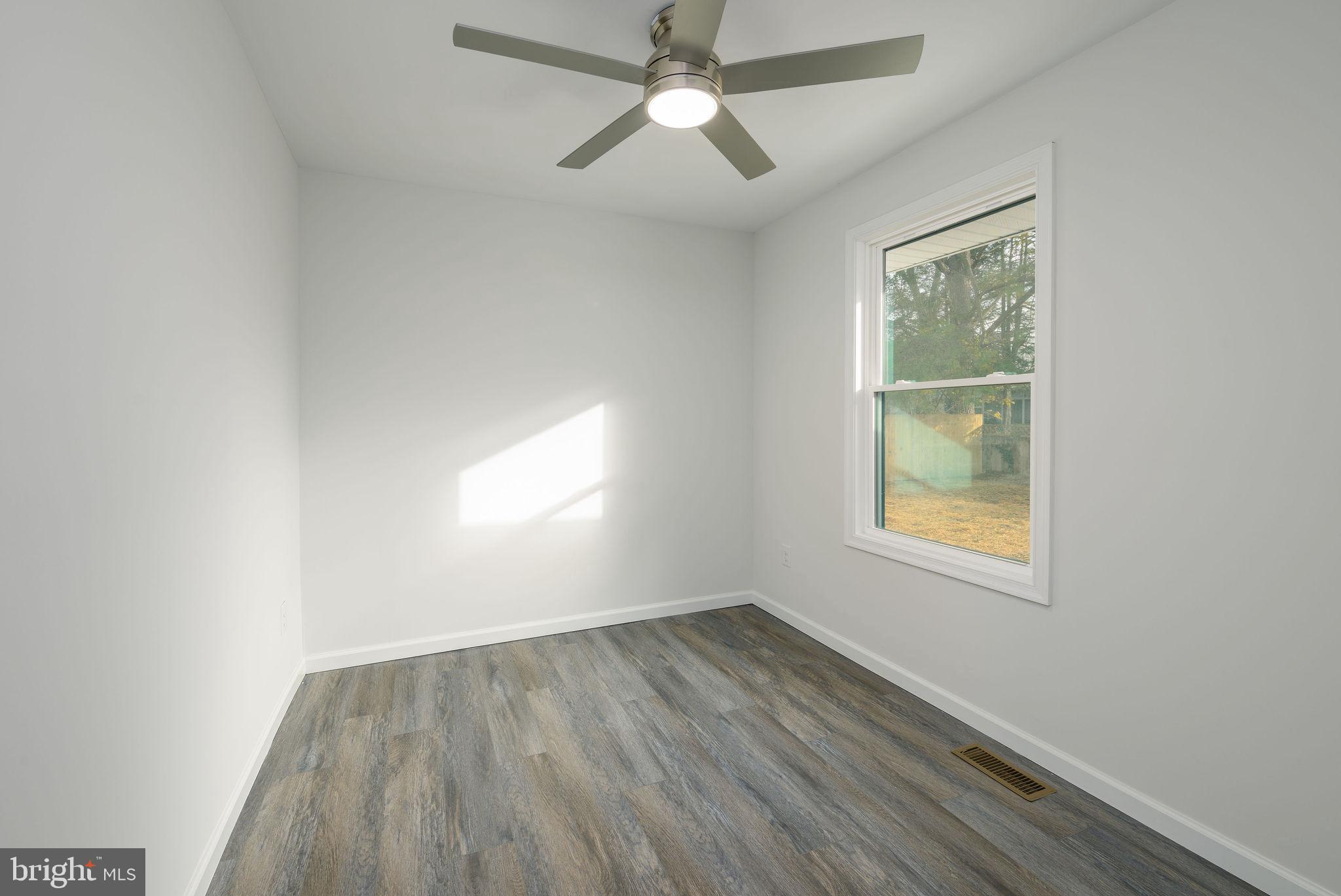 16853 Sherbrooke Road Lewes, DE 19958 - Photo 13 of 32 an empty room with a window and wooden floor