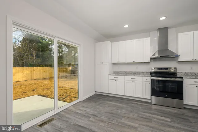 a kitchen with granite countertop white cabinets and white appliances