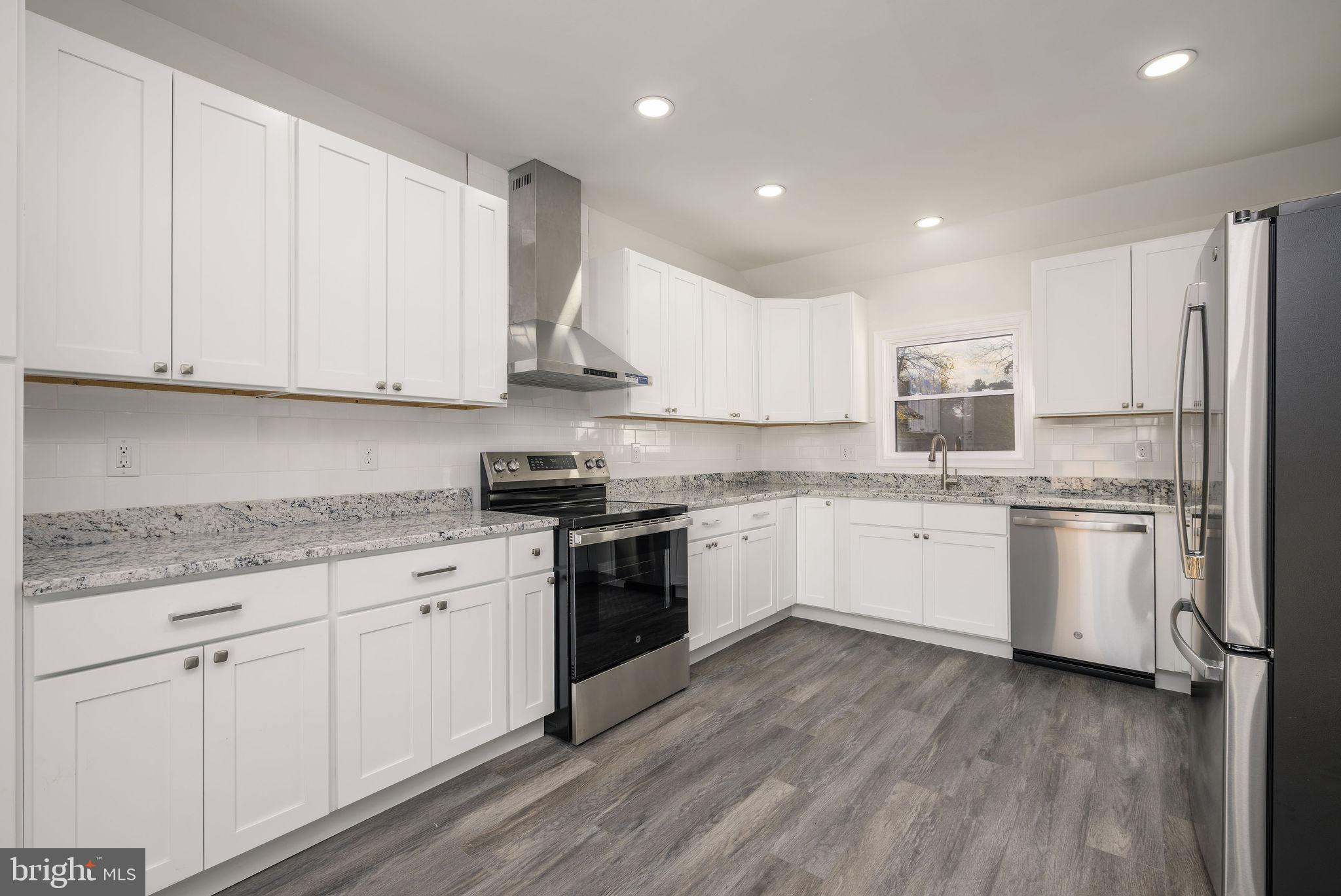 16853 Sherbrooke Road Lewes, DE 19958 - Photo 16 of 32 a kitchen with granite countertop white cabinets and white appliances