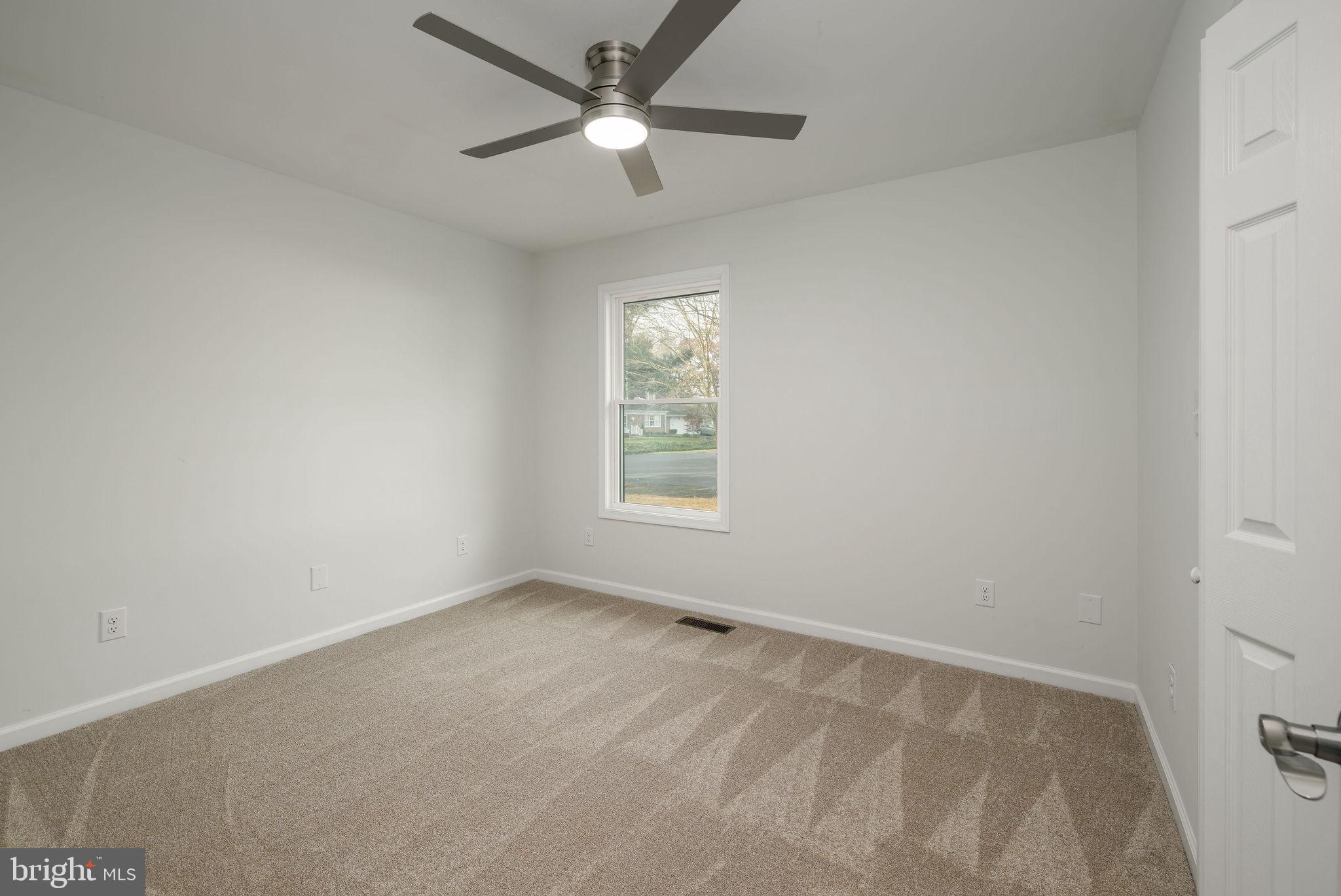 16853 Sherbrooke Road Lewes, DE 19958 - Photo 19 of 32 an empty room with a window and a fan
