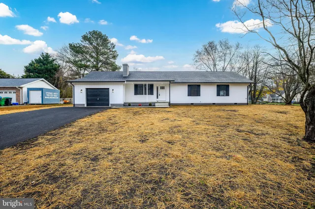 a front view of house with yard and trees