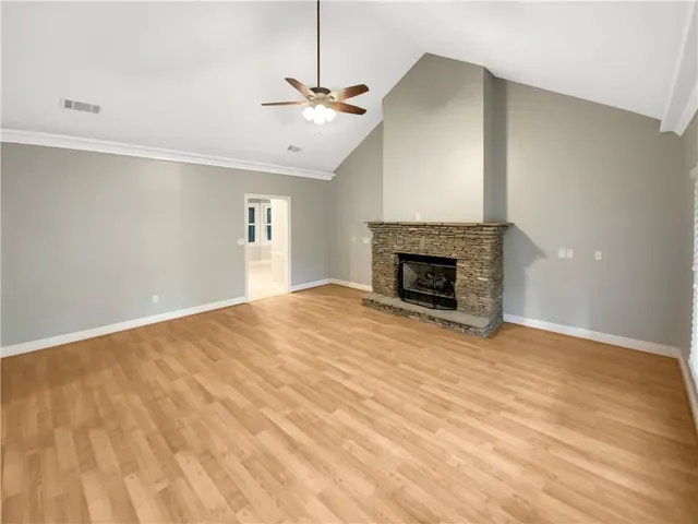a view of empty room with wooden floor and fireplace