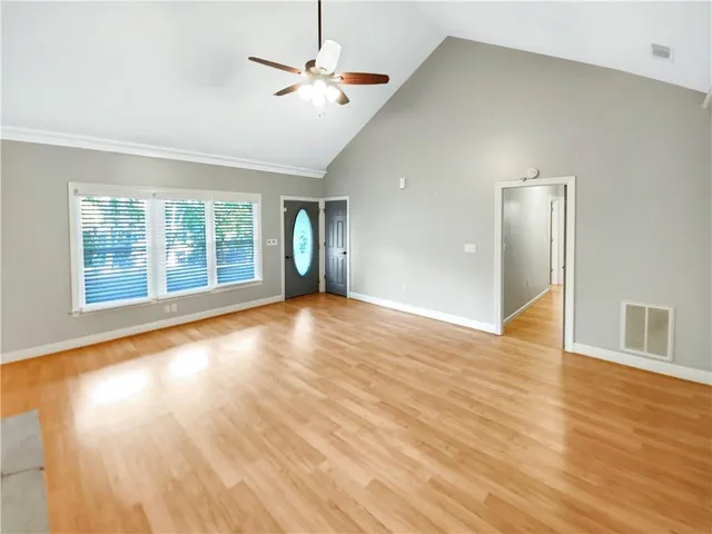 a view of an empty room with glass door and wooden floor