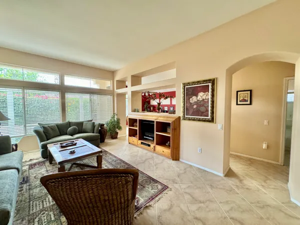 a living room with furniture a flat screen tv and a floor to ceiling window