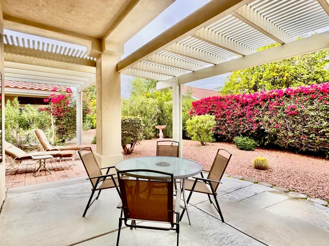 a view of an outdoor dining space with a table and chairs