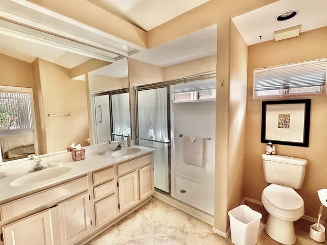 a bathroom with a granite countertop toilet sink and mirror