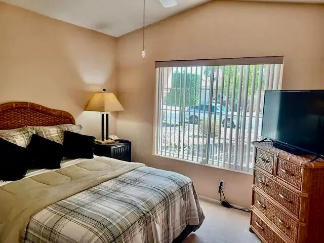 a bedroom with a bed and a flat tv screen on dresser