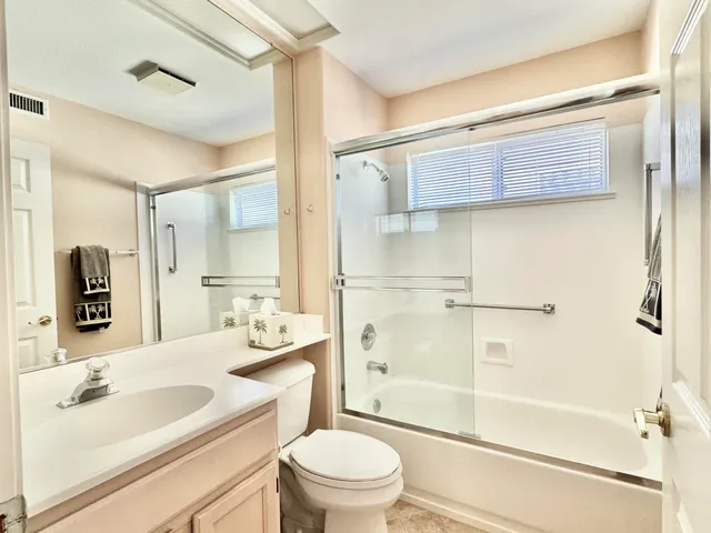 a bathroom with a sink a toilet and a large mirror