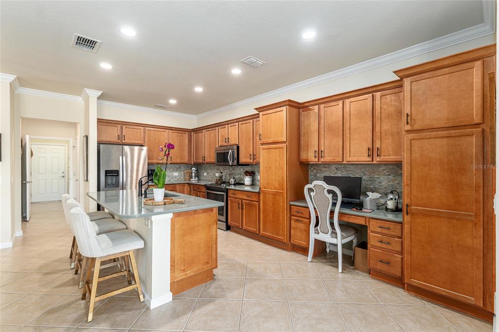 9595 Southwest 70th Loop Ocala, FL 34481 - Photo 35 of 100 a kitchen with a refrigerator a dining table and chairs