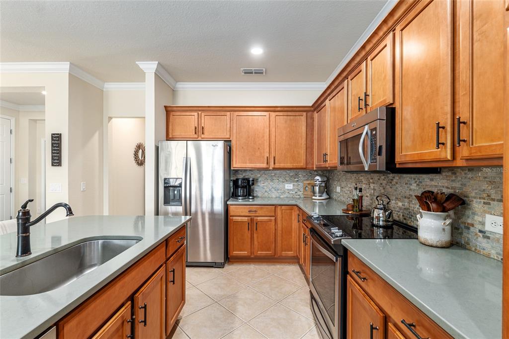 9595 Southwest 70th Loop Ocala, FL 34481 - Photo 40 of 100 a kitchen with stainless steel appliances granite countertop a sink stove and refrigerator