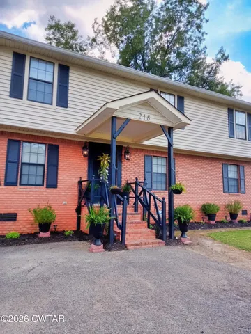 a view of a house with a yard and a street
