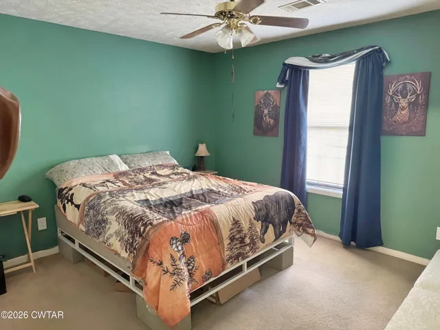 a bed sitting in a bedroom next to a window