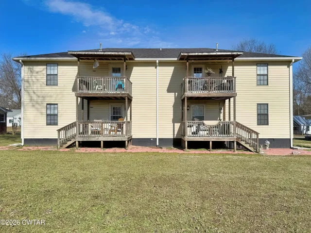 a view of a chair and table in backyard of the house
