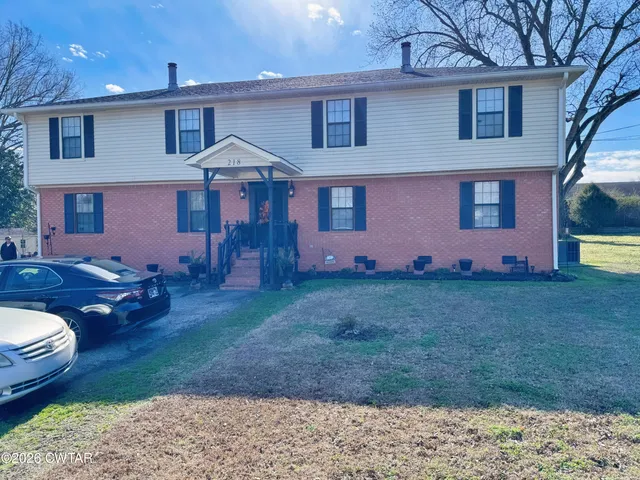 a backyard of a house with wooden fence and a bench