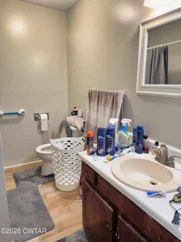 a bathroom with a granite countertop sink a toilet and mirror