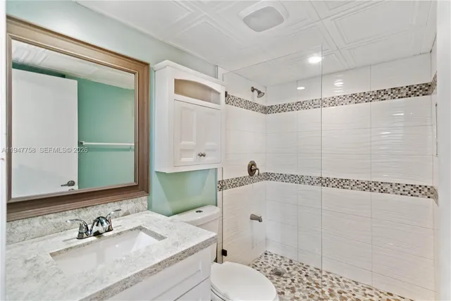 an empty room with wooden floor sink and mirror