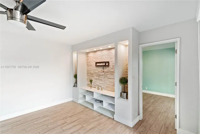a view of a room with wooden floor and white walls