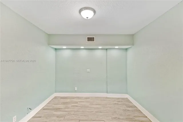 an empty room with wooden floor and door